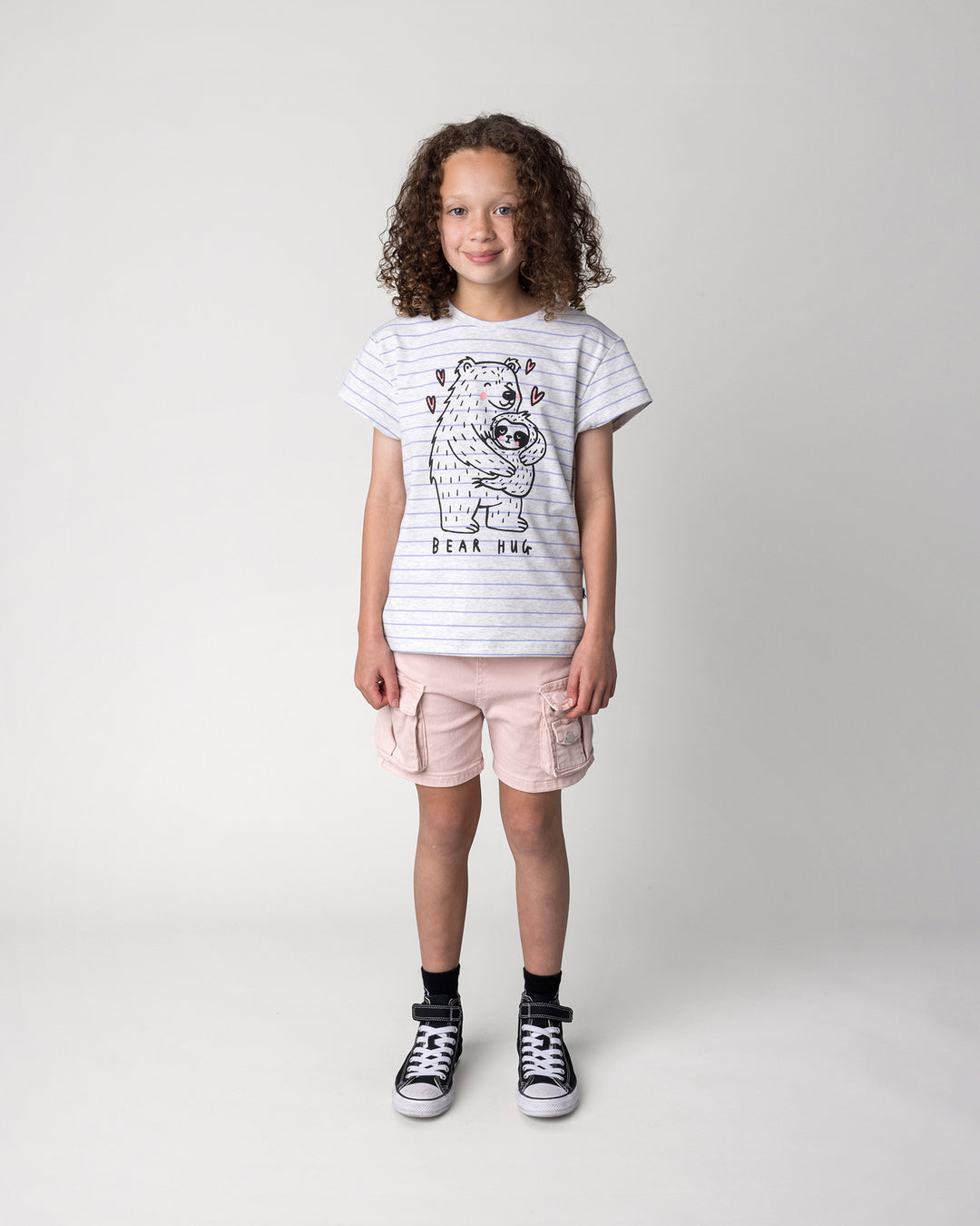 Kid wearing the Bear Hug Tee in marle and purple stripe, front view