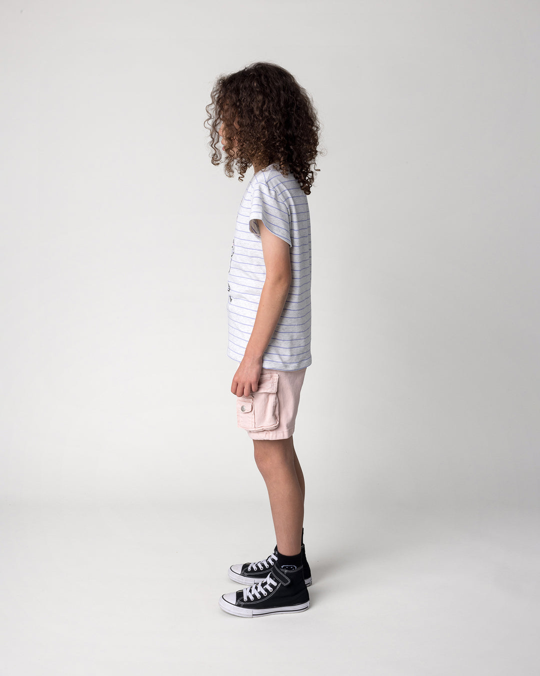 Kid wearing the Bear Hug Tee in marle and purple stripe, side view