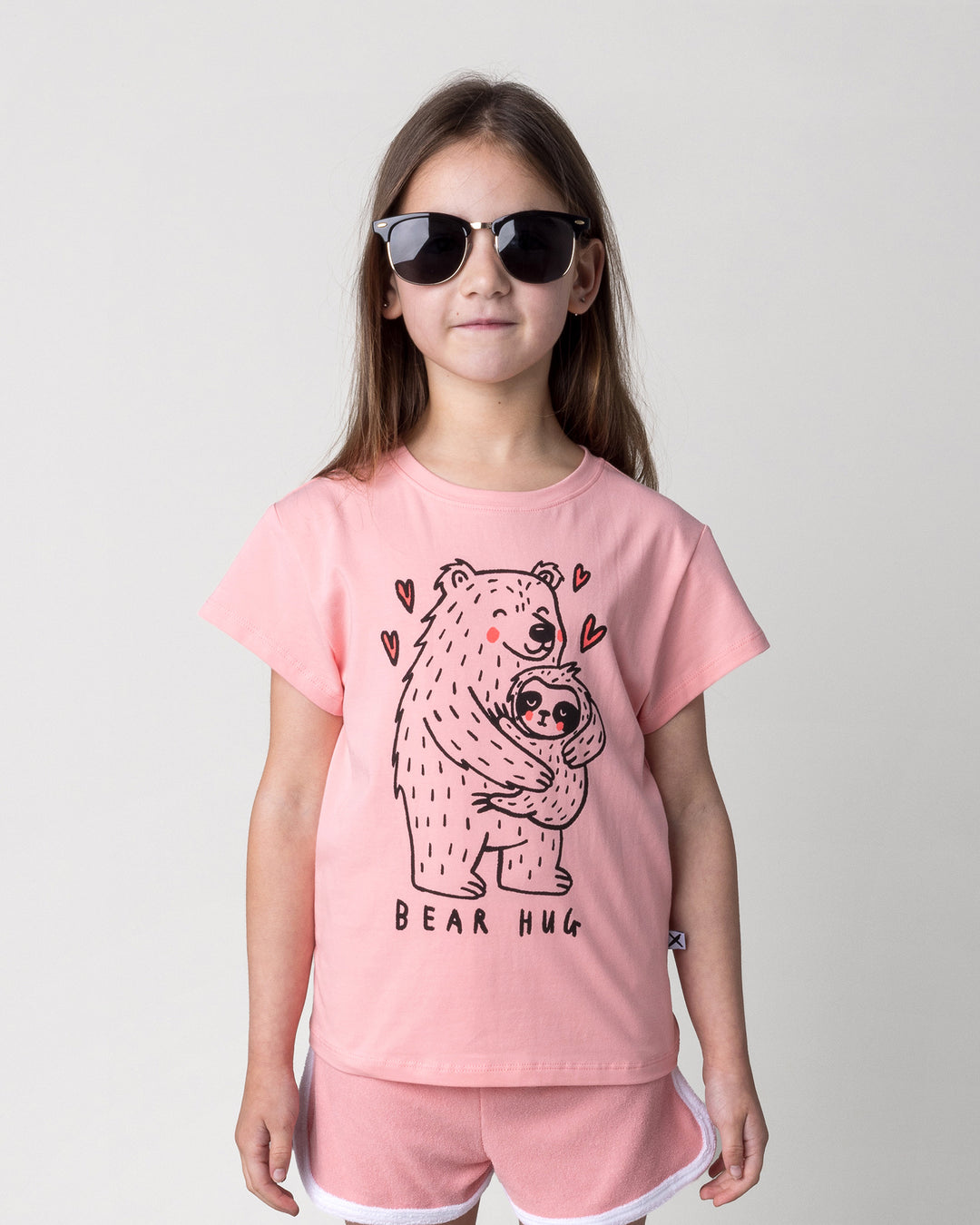 Close up of the Bear Hug Tee in pink on a kid, front view