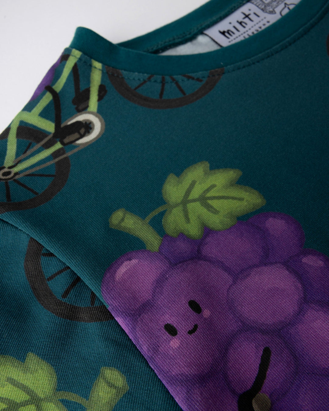 Close up of the Biking Grape Tee print in dark teal
