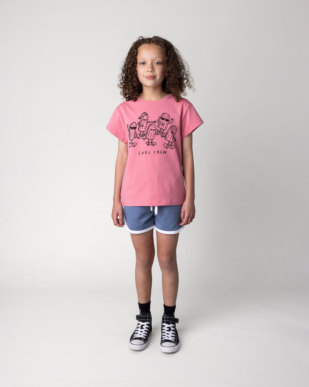 Kid wearing the Cool Crew Tee in candy with the Sprint Short in cornflower and white, front view