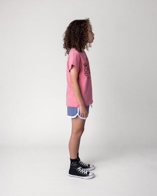 Kid wearing the Cool Crew Tee in candy with the Sprint Short in cornflower and white, side view
