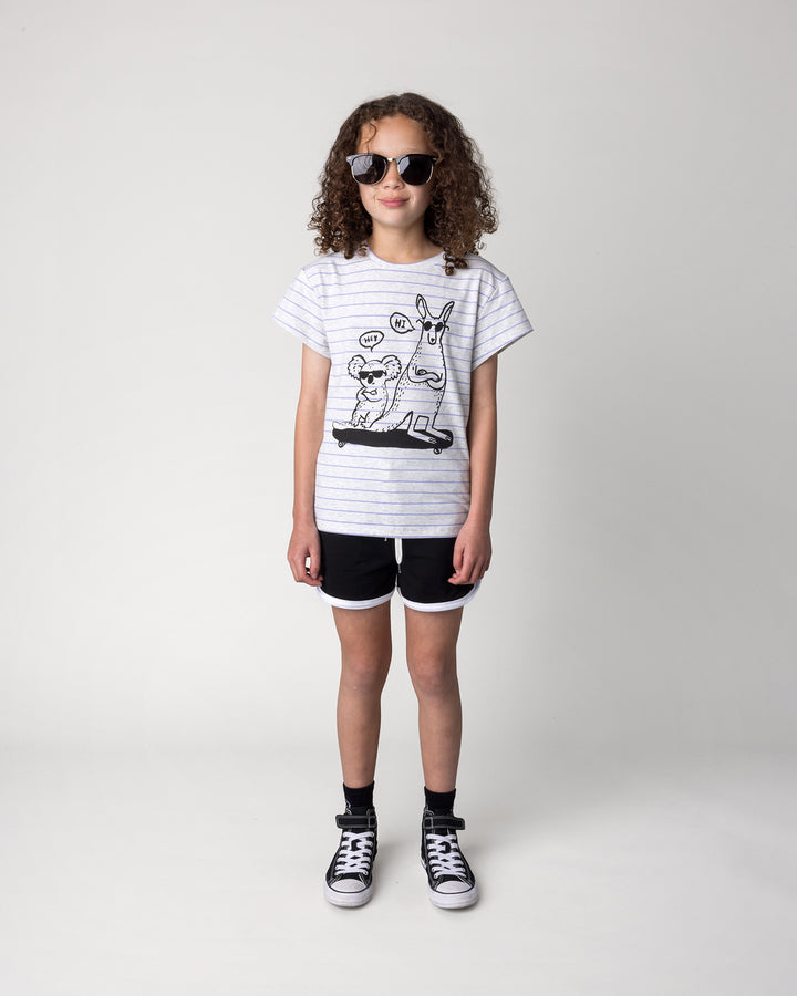 Kid wearing the Chill Mates Tee in marle and purple stripe with the Sprint Short in black and white, front view