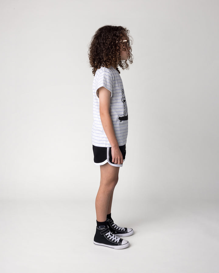 Kid wearing the Chill Mates Tee in marle and purple stripe with the Sprint Short in black and white, side view