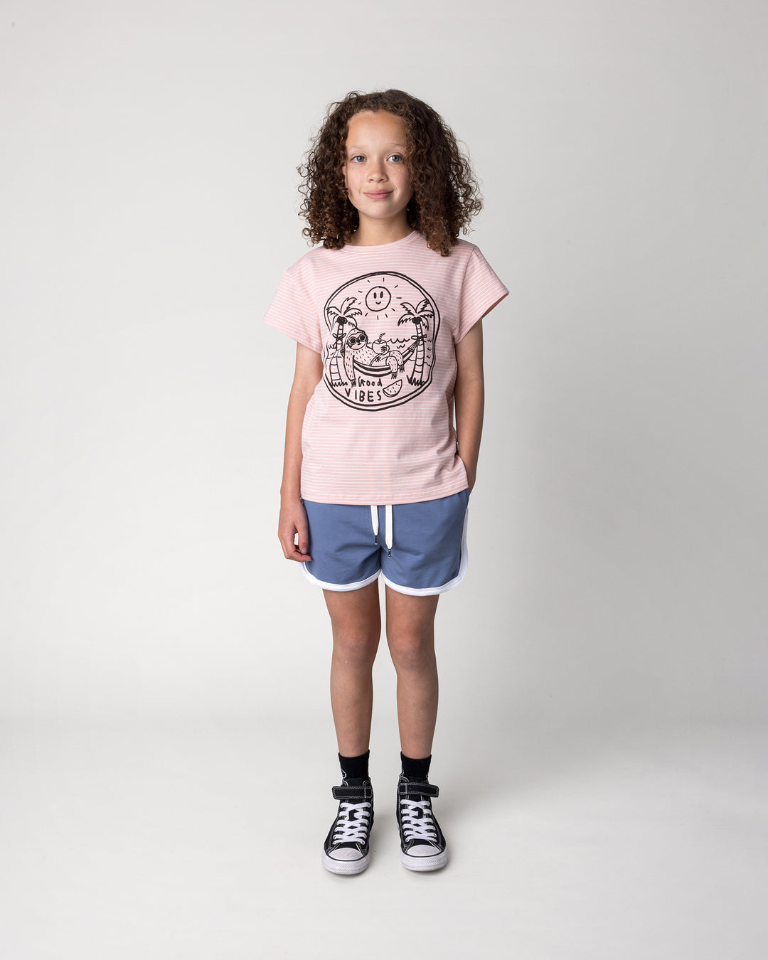 Kid wearing the Chill Sloth Tee in ballet stripe with the Sprint Short in cornflower and white, front view