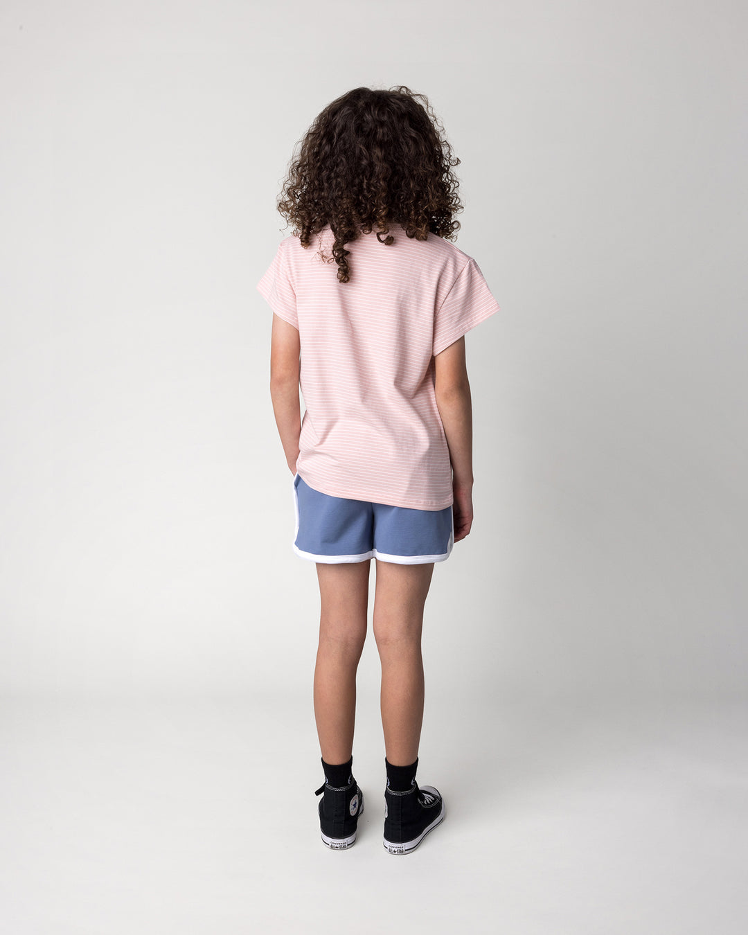 Kid wearing the Chill Sloth Tee in ballet stripe with the Sprint Short in cornflower and white, back view