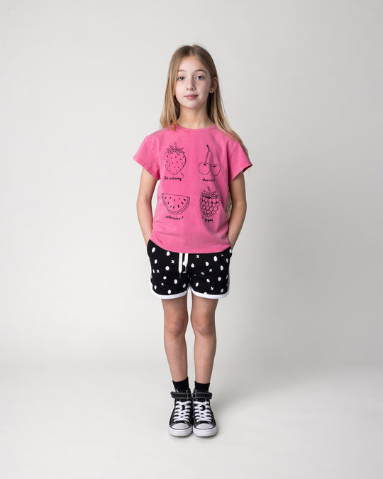 Kid wearing the Different Fruits Tee in pink wash with the Spotty Short in black and white, front view