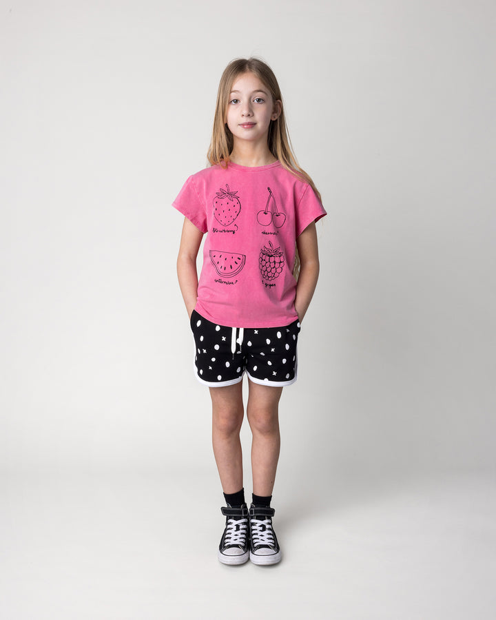 Kid wearing the Different Fruits Tee in pink wash with the Spotty Short in black and white, front view