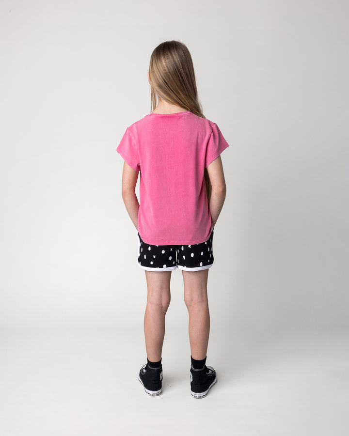 Kid wearing the Different Fruits Tee in pink wash with the Spotty Short in black and white, back view