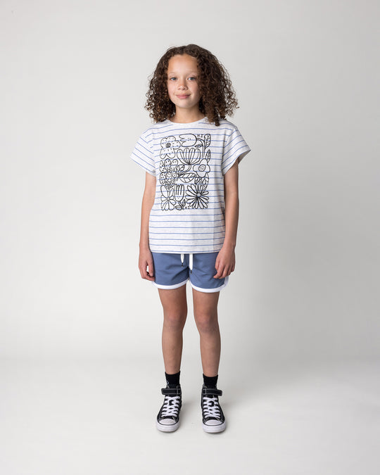 Kid wearing the Flower Party Tee in marle and blue stripe with the Sprint Short in cornflower and white, front view