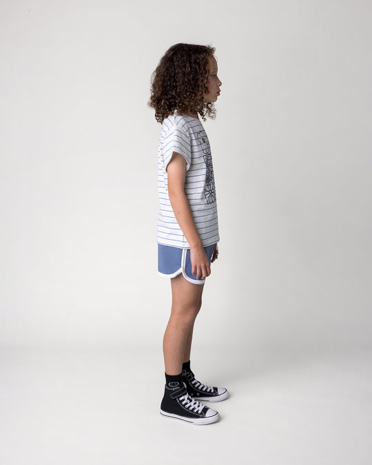 Kid wearing the Flower Party Tee in marle and blue stripe with the Sprint Short in cornflower and white, side view