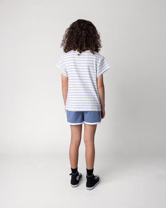 Kid wearing the Flower Party Tee in marle and blue stripe with the Sprint Short in cornflower and white, back view