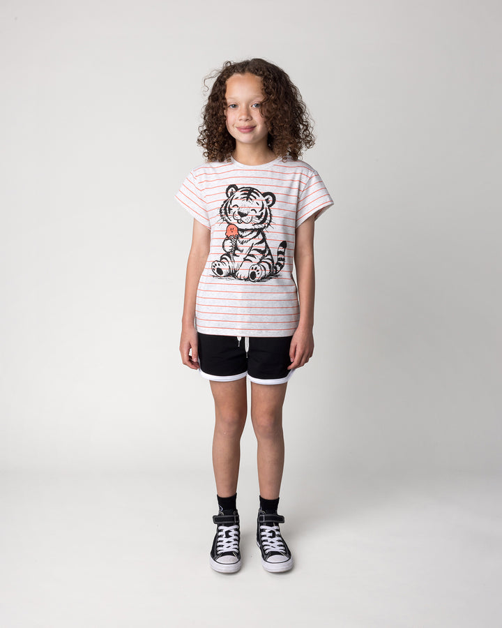 Kid wearing the Happy Tiger Tee in marle and coral stripe with the Sprint Short in black and white, front view