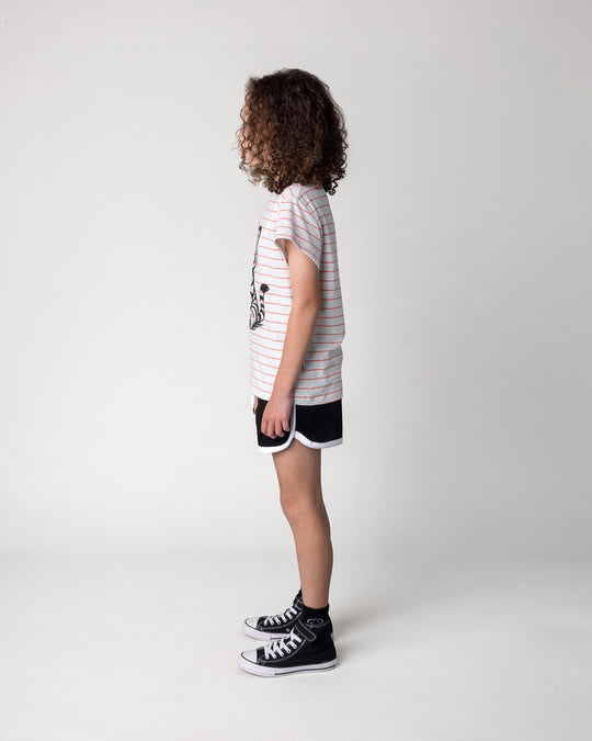 Kid wearing the Happy Tiger Tee in marle and coral stripe with the Sprint Short in black and white, side view