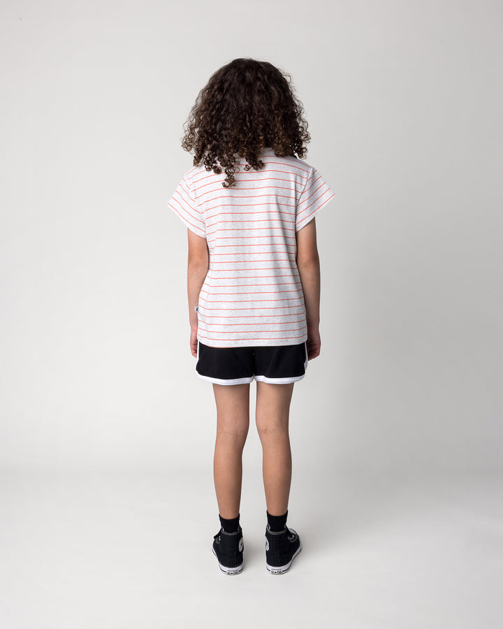 Kid wearing the Happy Tiger Tee in marle and coral stripe with the Sprint Short in black and white, back view