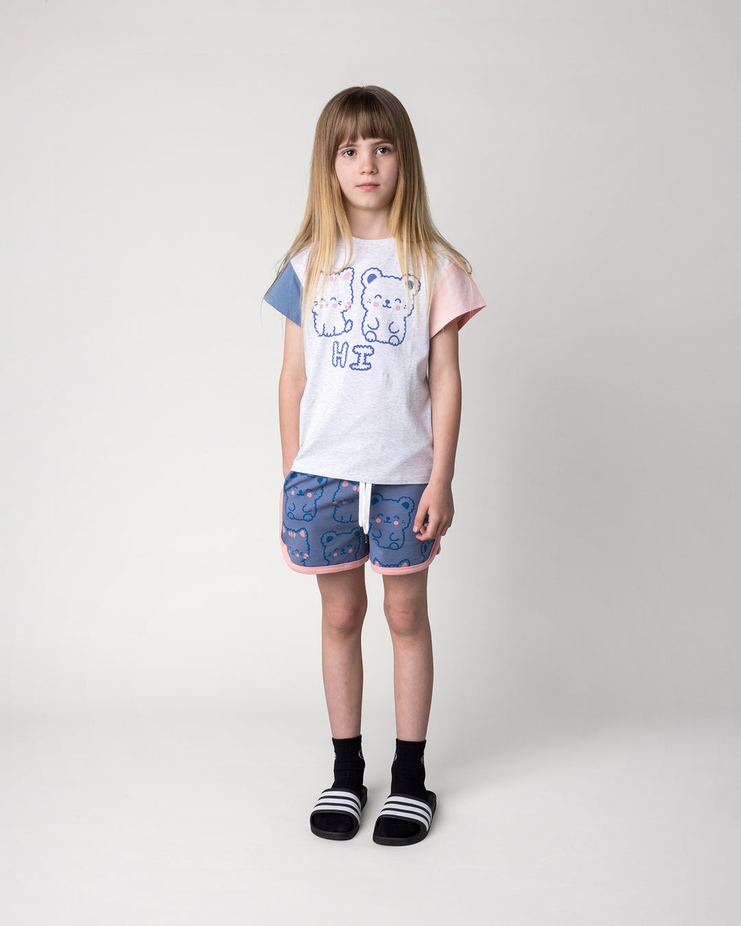 Kid wearing the Hi Cat Bear Tee in white marle, blue and pink with the Hi Cat Bear Short in cornflower and pink, front view