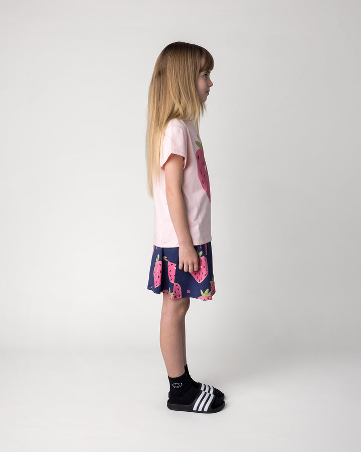 Kid wearing the Happy Strawberry Tee in pink marle with the Happy Strawberry Skirt in turquoise, side view
