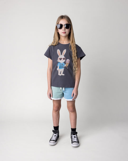 Kid wearing the Icecream Bunny Tee in dark grey with the Sprint Short in mint, aqua and lilac, front view