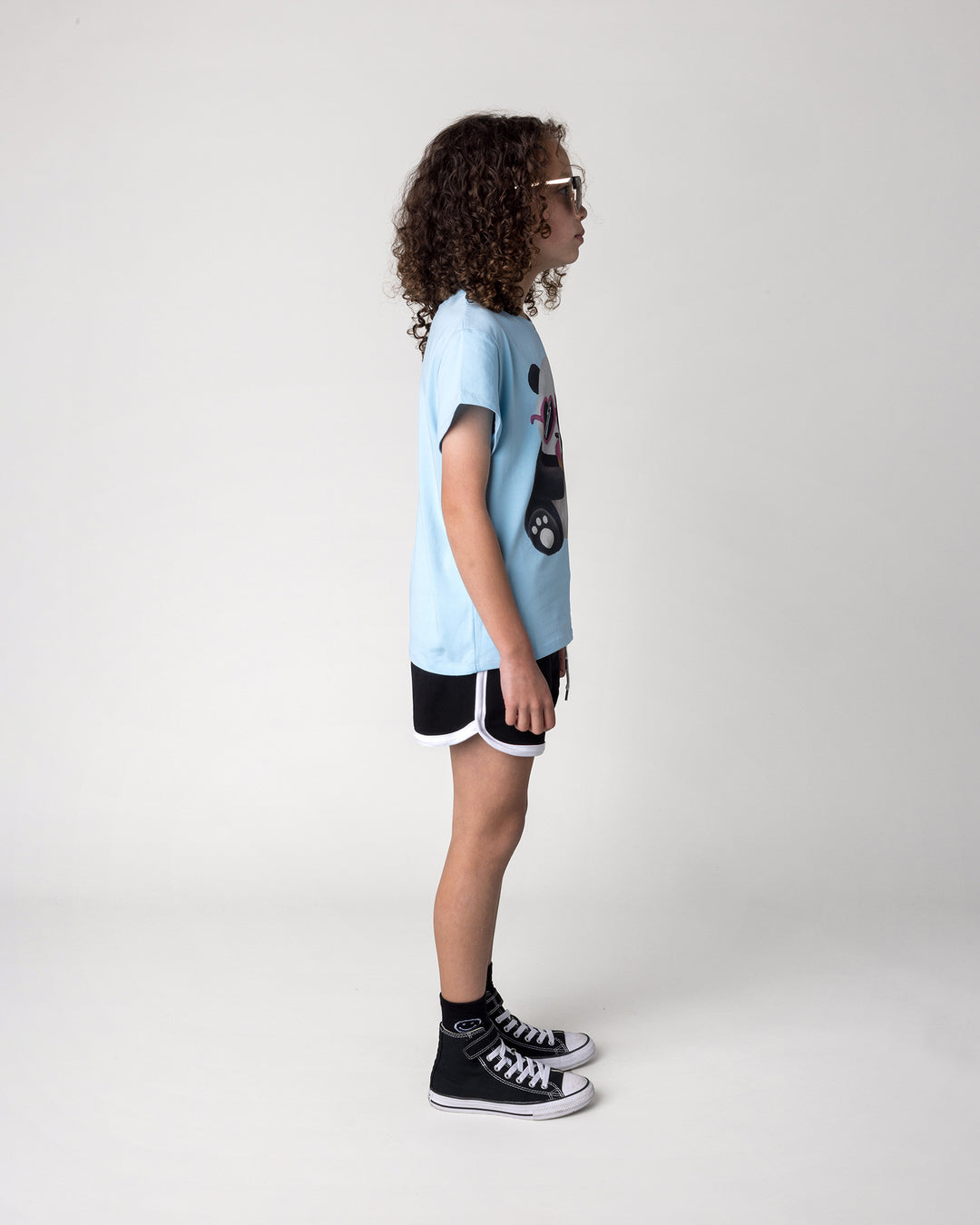 Kid wearing the Icecream Panda Tee in light blue with the Sprint Short in black and white, side view