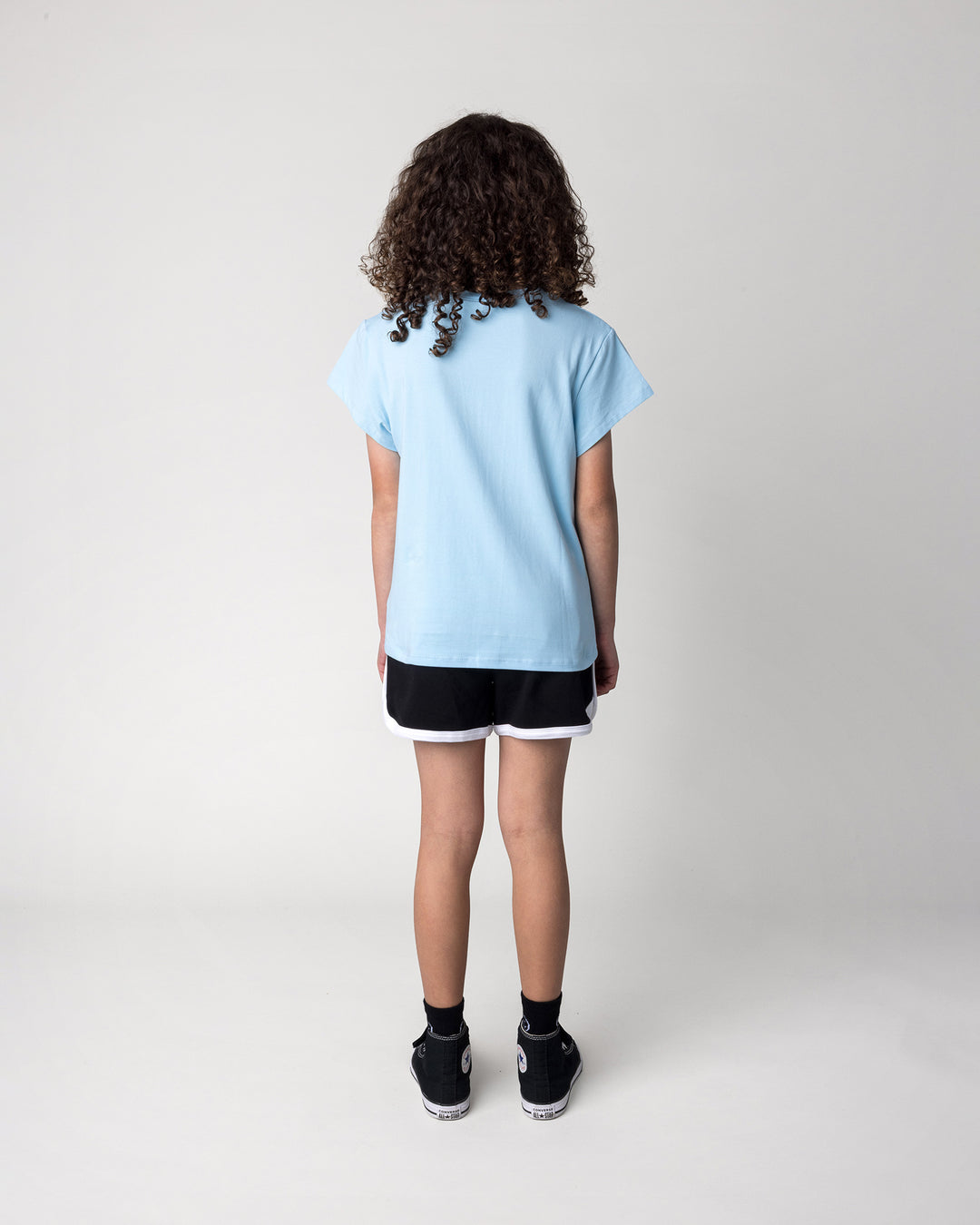 Kid wearing the Icecream Panda Tee in light blue with the Sprint Short in black and white, back view