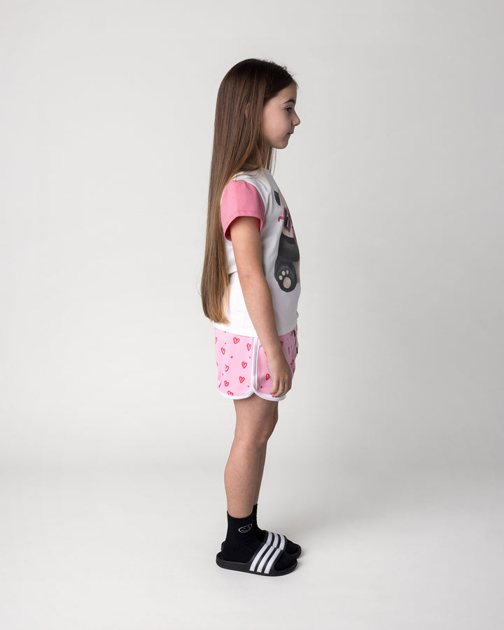 Kid wearing the Icecream Panda Tee in white and candy with the Hearts Short in pink and white, side view