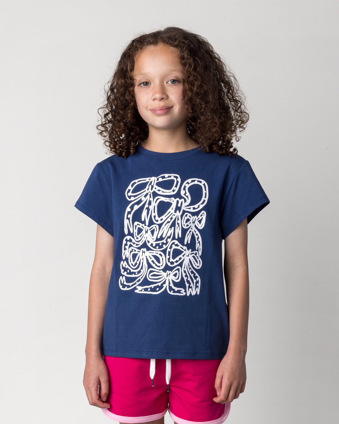 Close up of the Messy Bows Tee in ink on a kid, front view