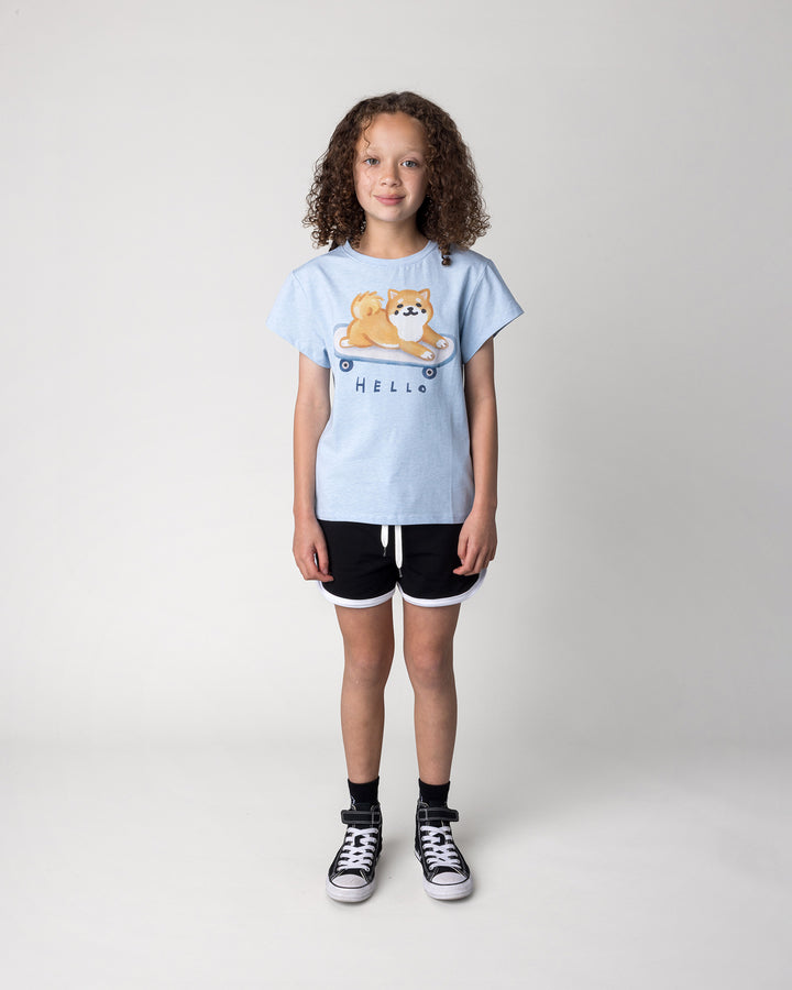 Kid wearing the Skate Puppy Tee in light blue marle with the Sprint Short in black and white, front view