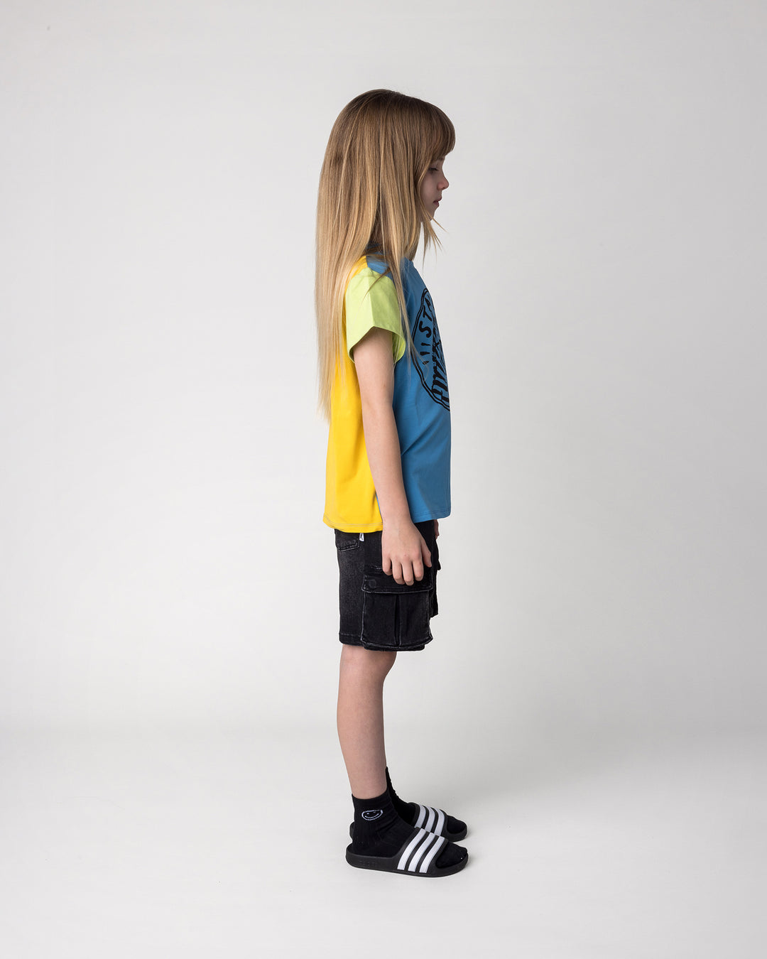 Kid wearing the Stay Cool Tee in multi, side view
