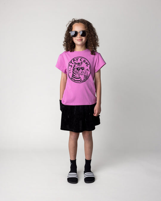 Kid wearing the Stay Cool Tee in violet with the Velvet Skirt in black, front view