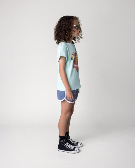 Kid wearing the Swimming Sloth Tee in mint marle with the Sprint Short in cornflower and white, side view