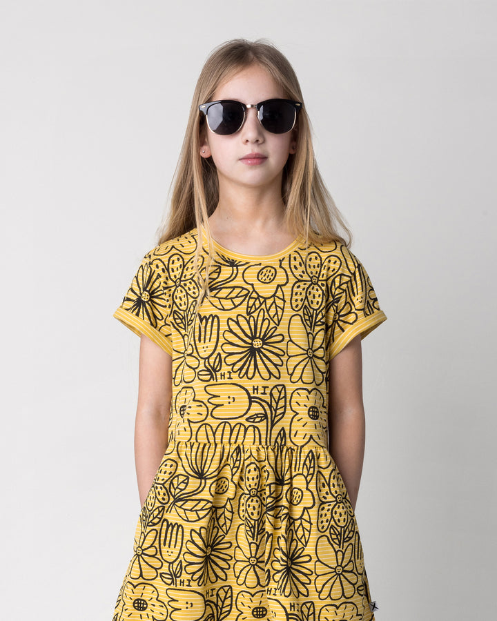 Close up of the Big Flowers Dress in mustard stripe on a kid, front view