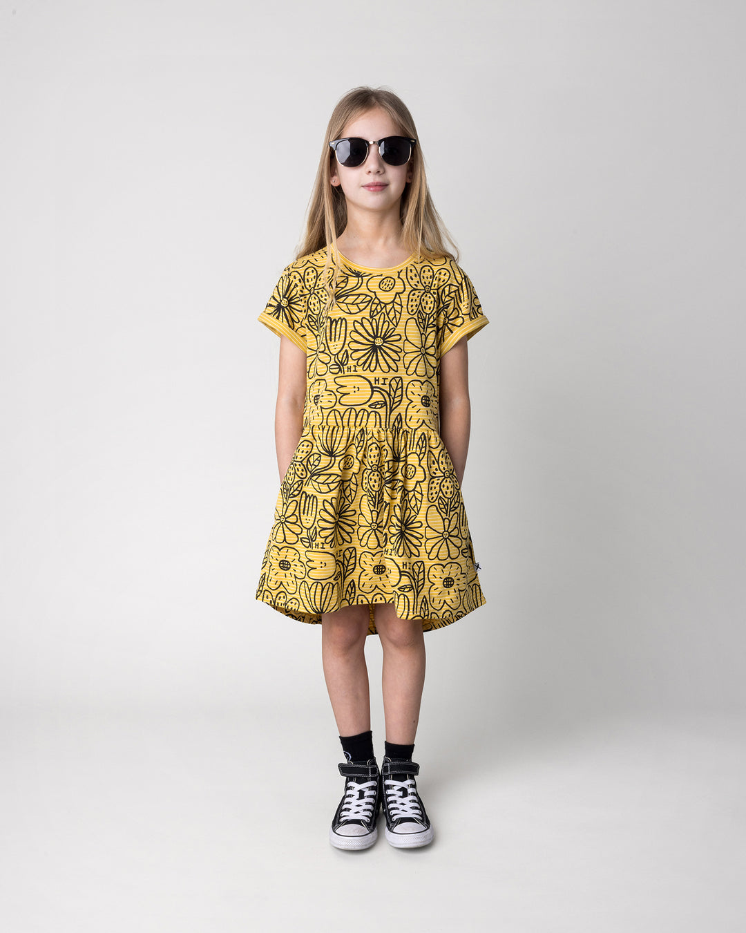 Kid wearing the Big Flowers Dress in mustard stripe, front view