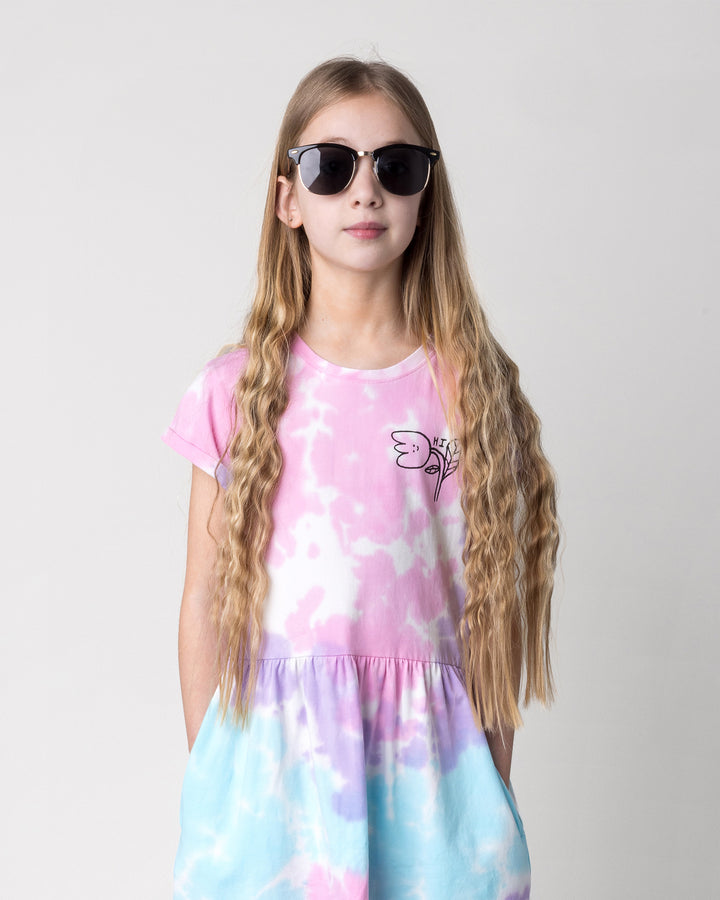 Close up of the Pocket Flower Dress in tie dye on a kid, front view