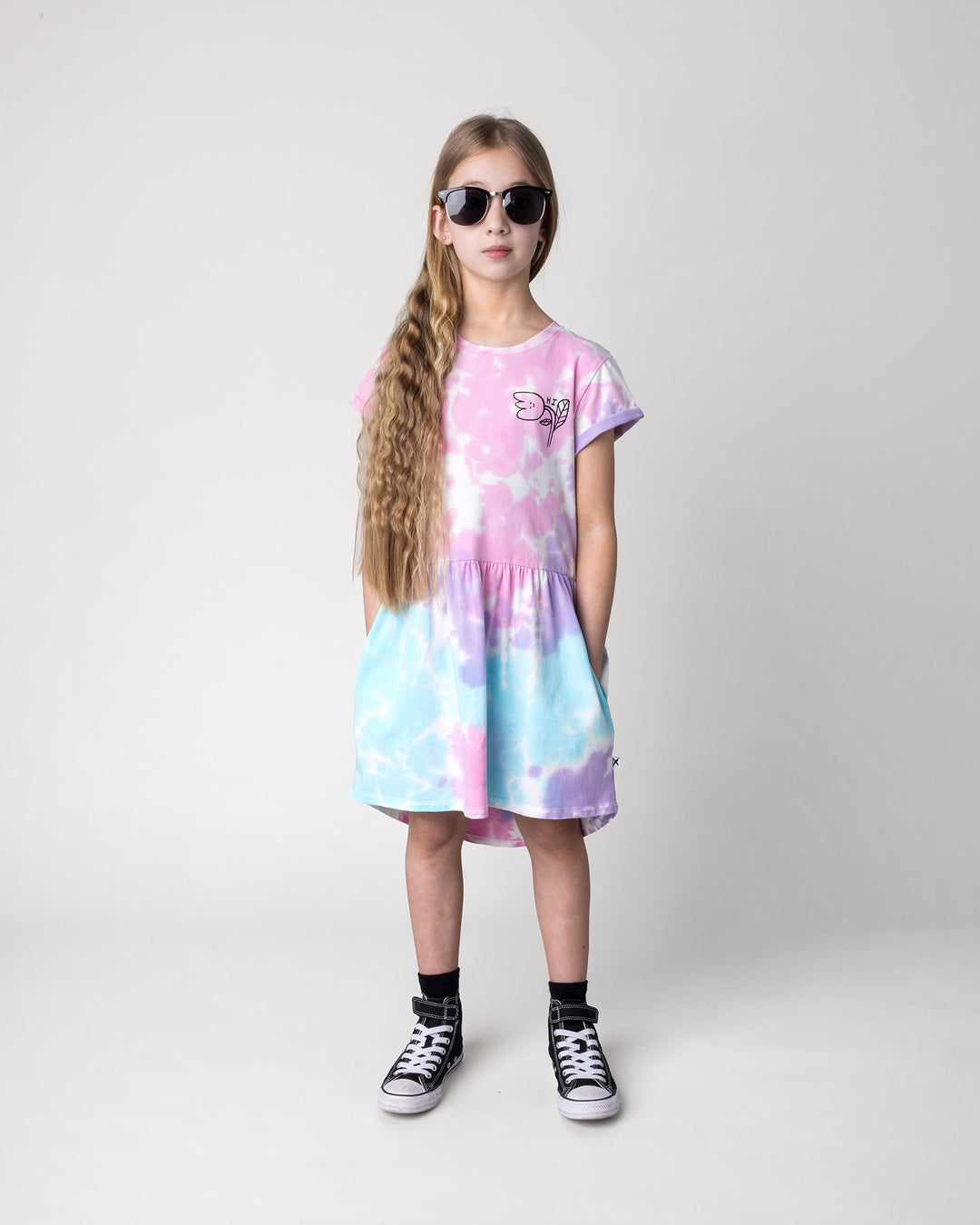 Kid wearing the Pocket Flower Dress in tie dye, front view