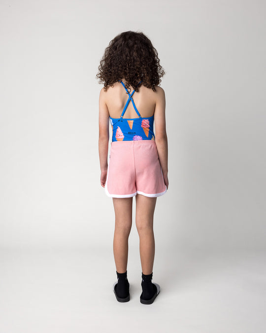 Kid wearing the Happy Icecreams Swimsuit in bright blue with the Track Star Short in pink, back view