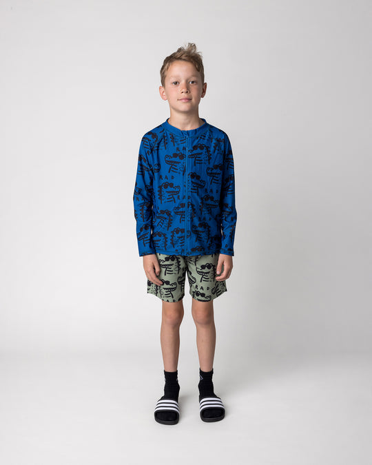 Kid wearing the Rad Croc Rashie in midnight with the Rad Croc Boardies in khaki, front view