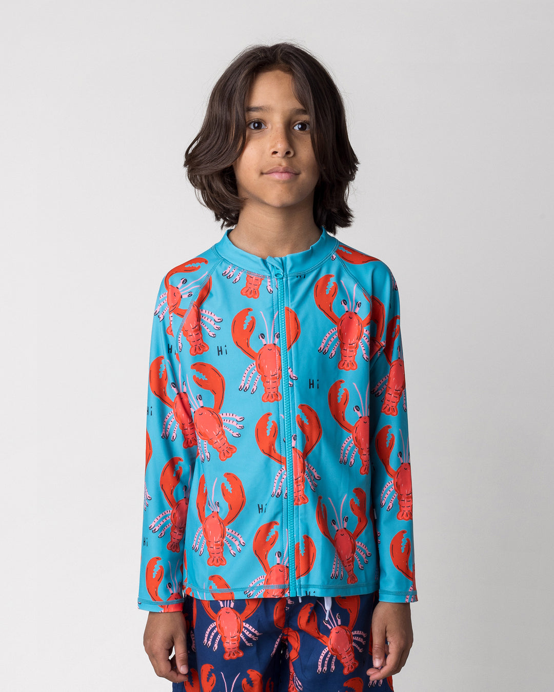 Close up of the Vacay Crayfish Rashie in teal on a kid, front view