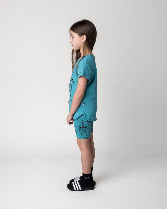 Kid wearing the Bear Hug Tee in emerald with the Bear Hug Bike Pant in emerald, side view