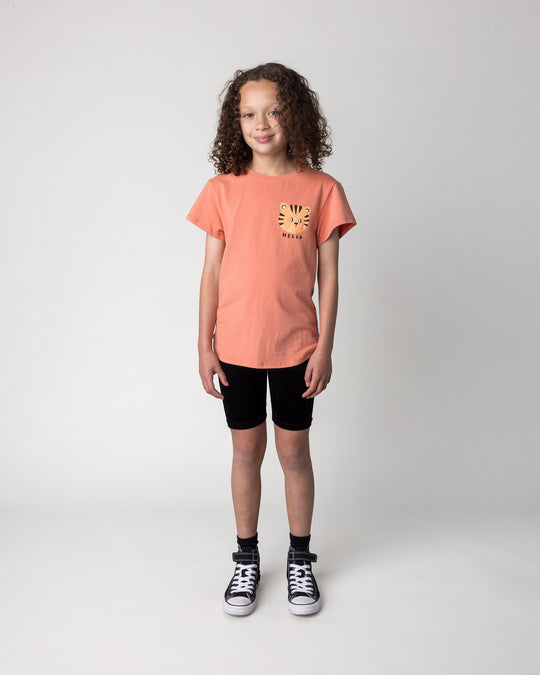 Kid wearing the Hello Tiger Tee in apricot with the Velvet Bike Pant in black, front view