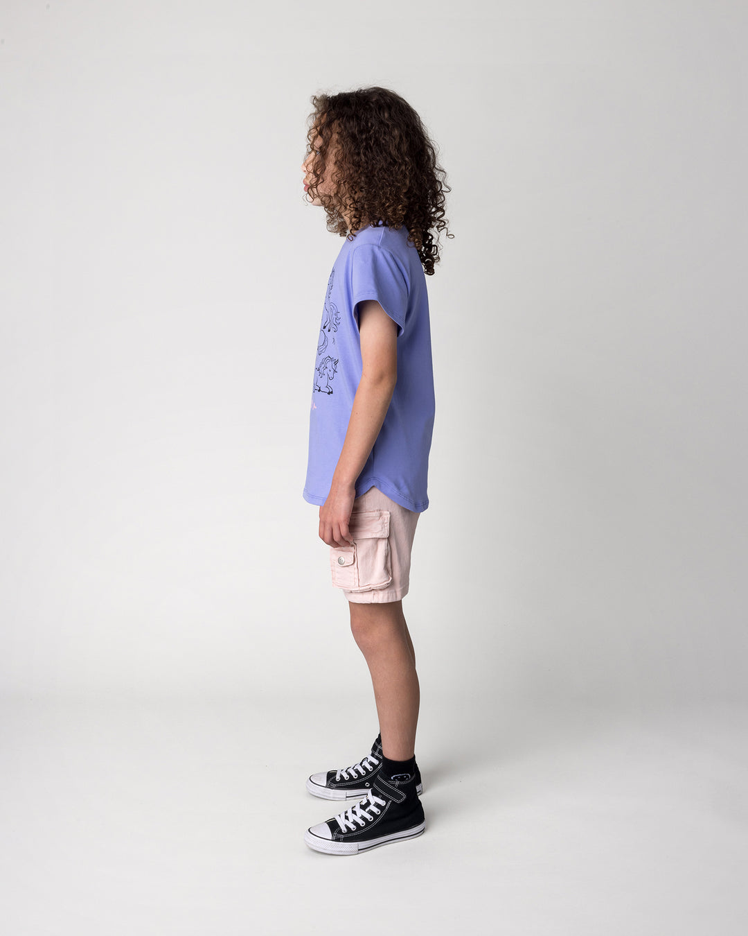 Kid wearing the Hello Unicorns Tee in purple, side view