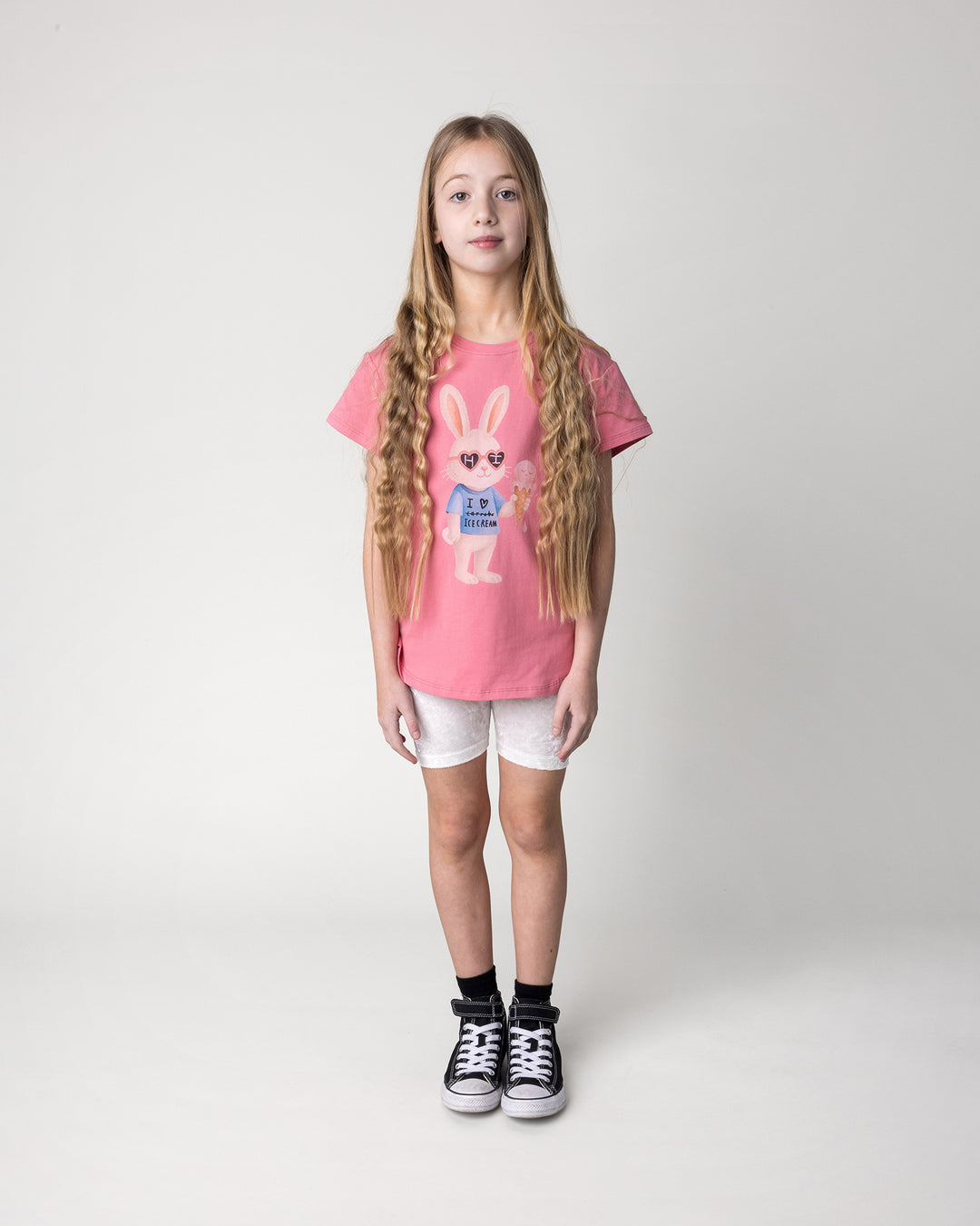 Kid wearing the Icecream Bunny Tee in candy with the Velvet Bike Pant in cream, front view