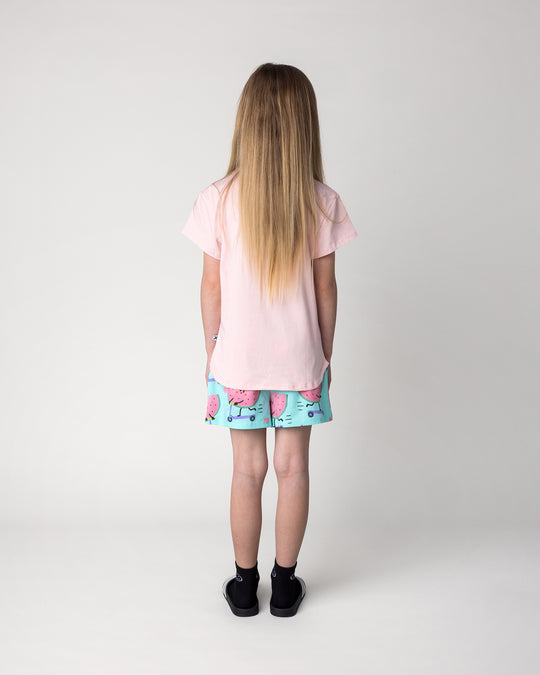 Kid wearing the Scooting Watermelon Tee in light pink with the Scooting Watermelon Short in light mint, back view