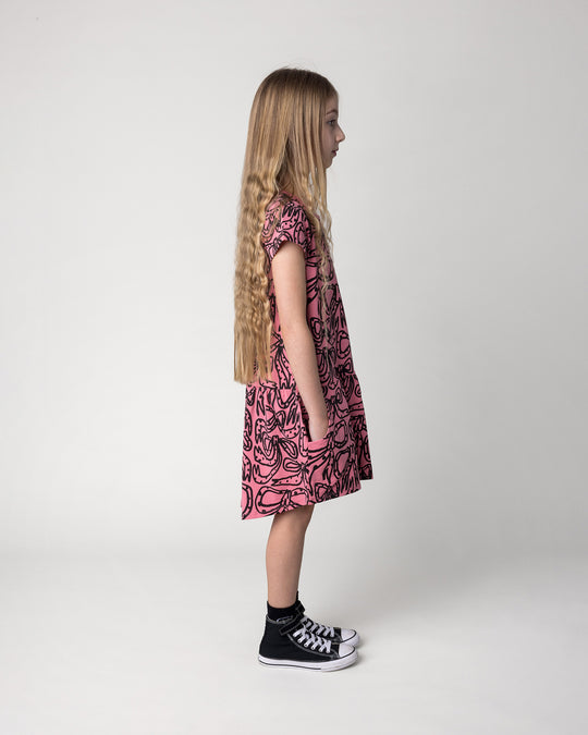 Kid wearing the Big Bows Dress in candy, side view