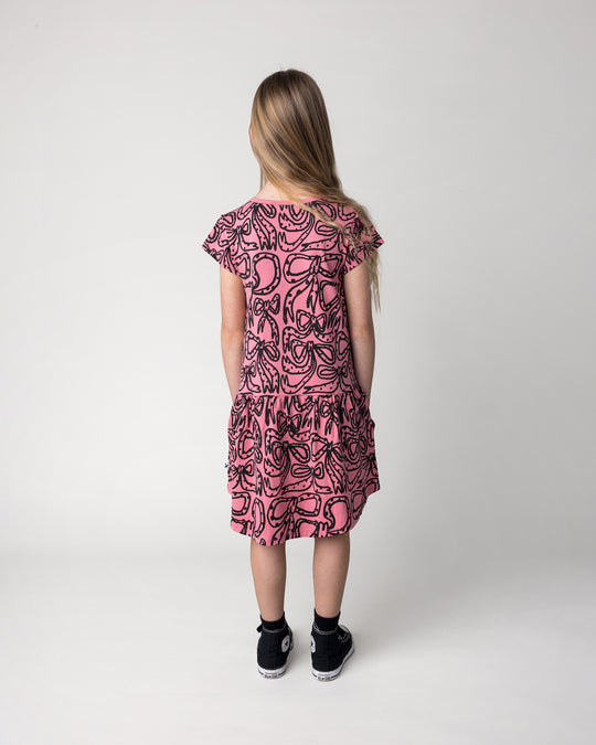 Kid wearing the Big Bows Dress in candy, back view
