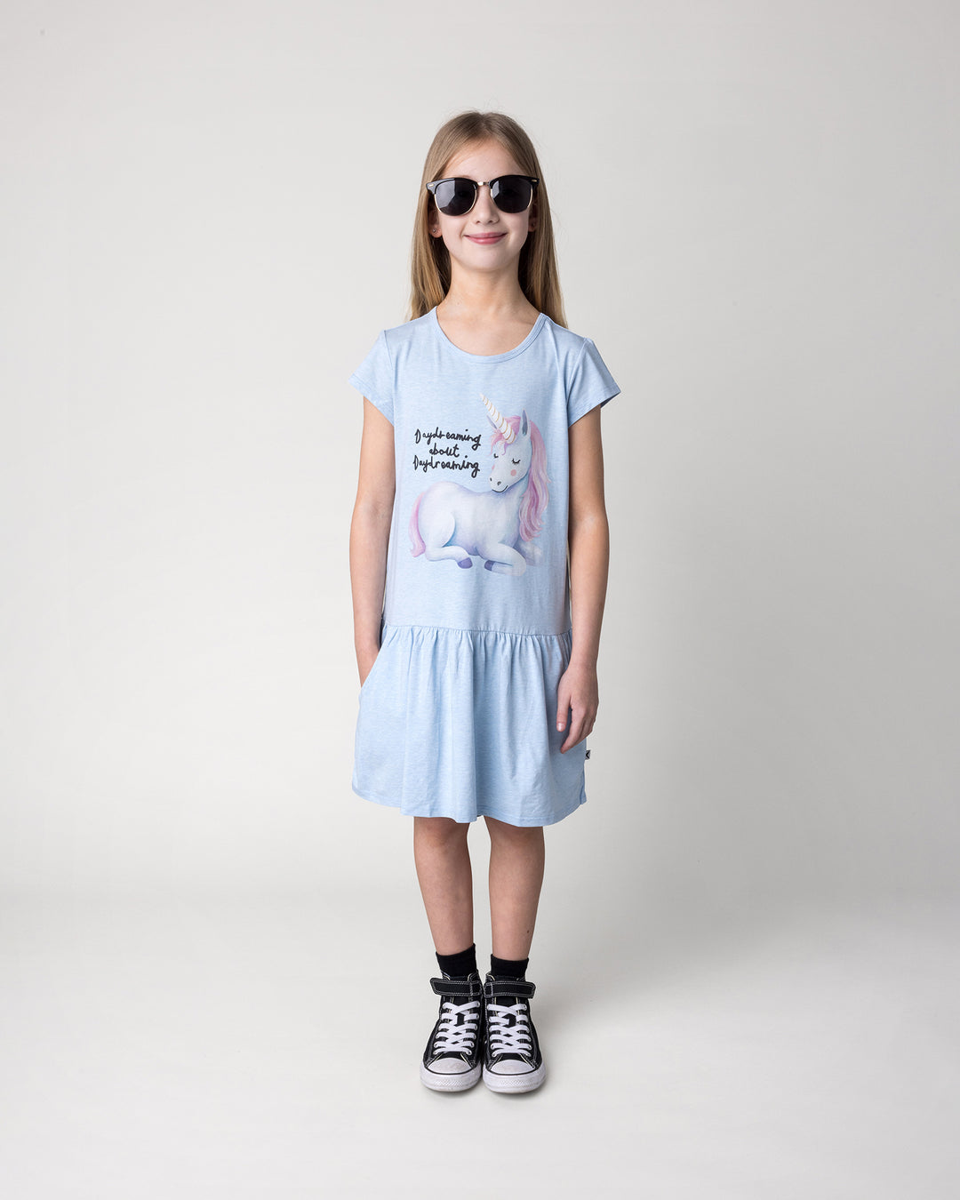 Kid wearing the Daydreaming Unicorn Dress in light blue marle, front view