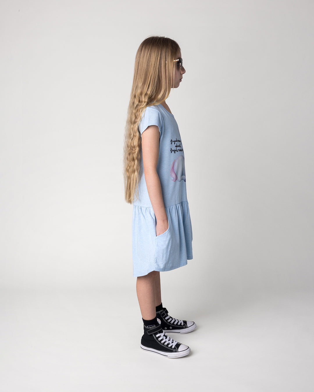 Kid wearing the Daydreaming Unicorn Dress in light blue marle, side view