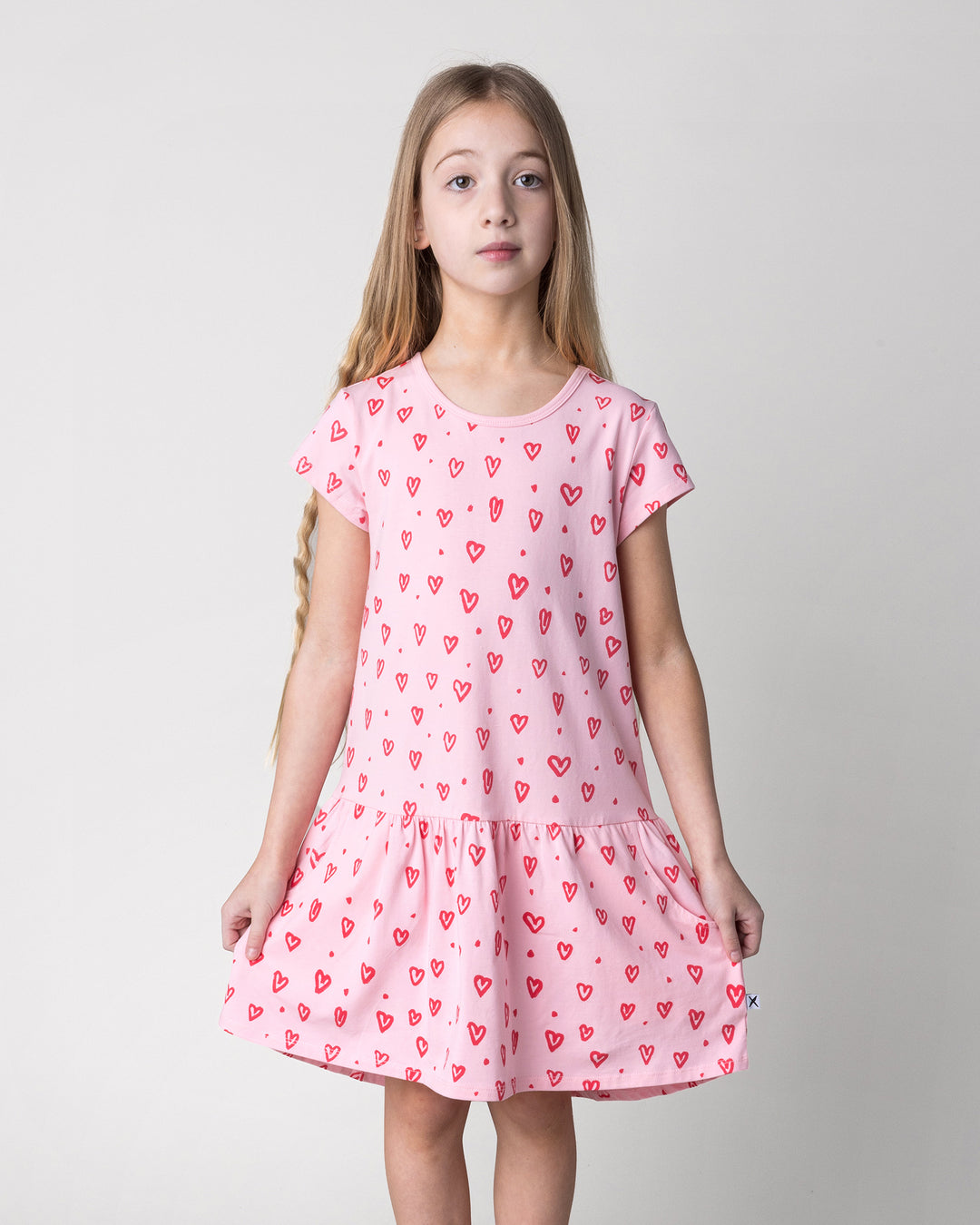 Close up of the Hearts Dress in pink on a kid, front view