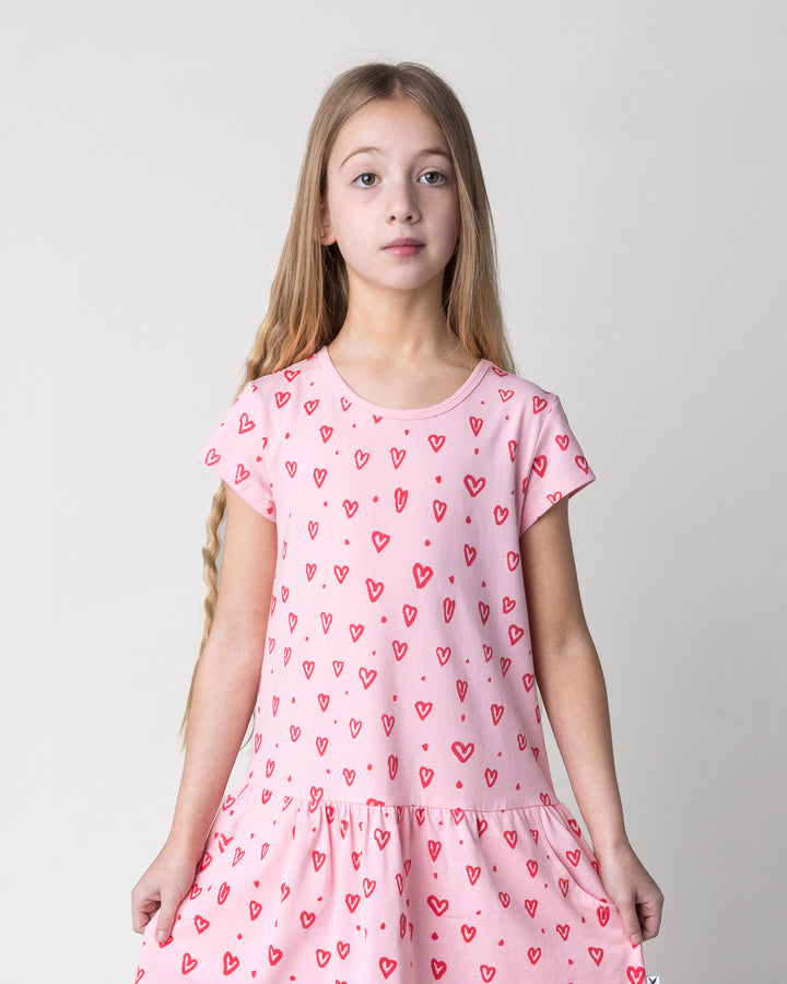 Close up of the Hearts Dress in pink on a kid, front view