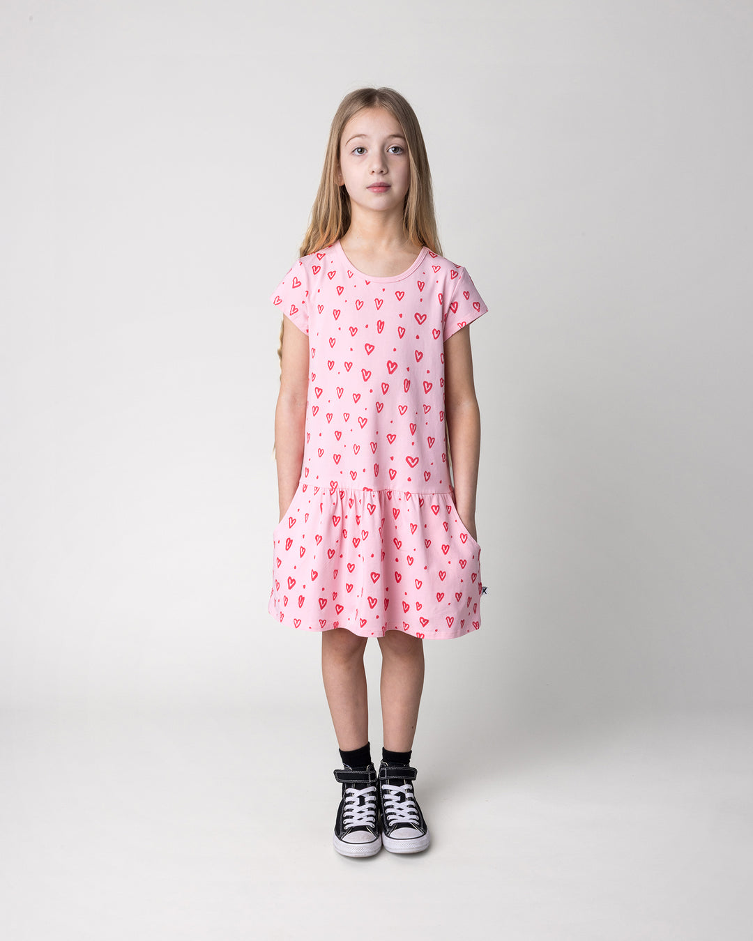 Kid wearing the Hearts Dress in pink, front view