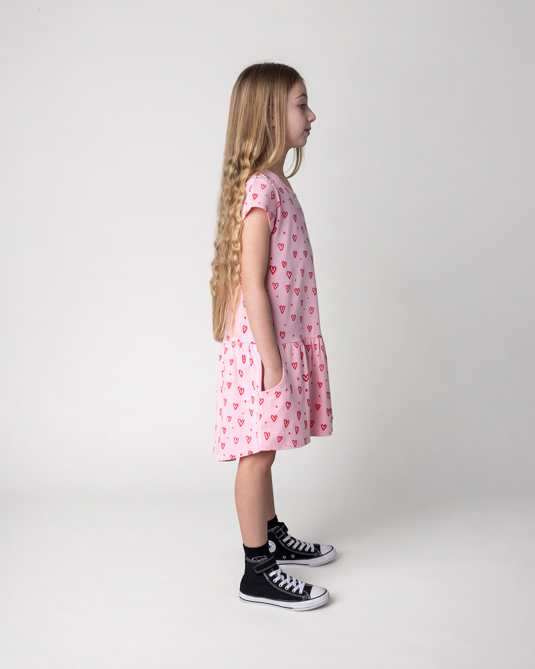 Kid wearing the Hearts Dress in pink, side view